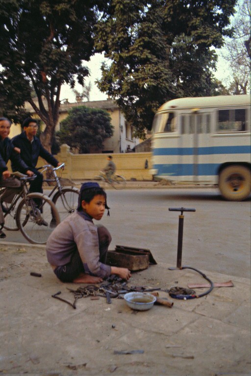 Còn cậu bé này đang sửa xe đạp ở trên đường Hai Bà Trưng, Hà Nội.